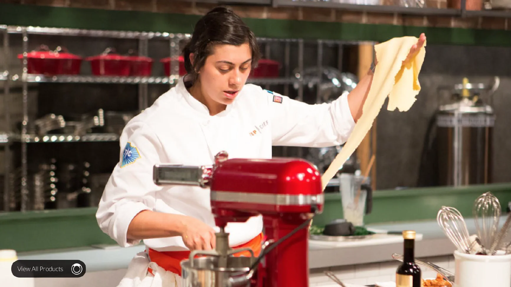 Chef preparing pasta dough with a red stand mixer.